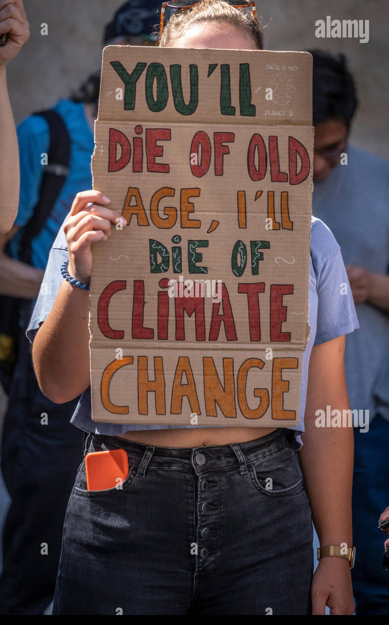 Un manifestante sostiene un cartel que dice: "Morirás de viejo. Yo...